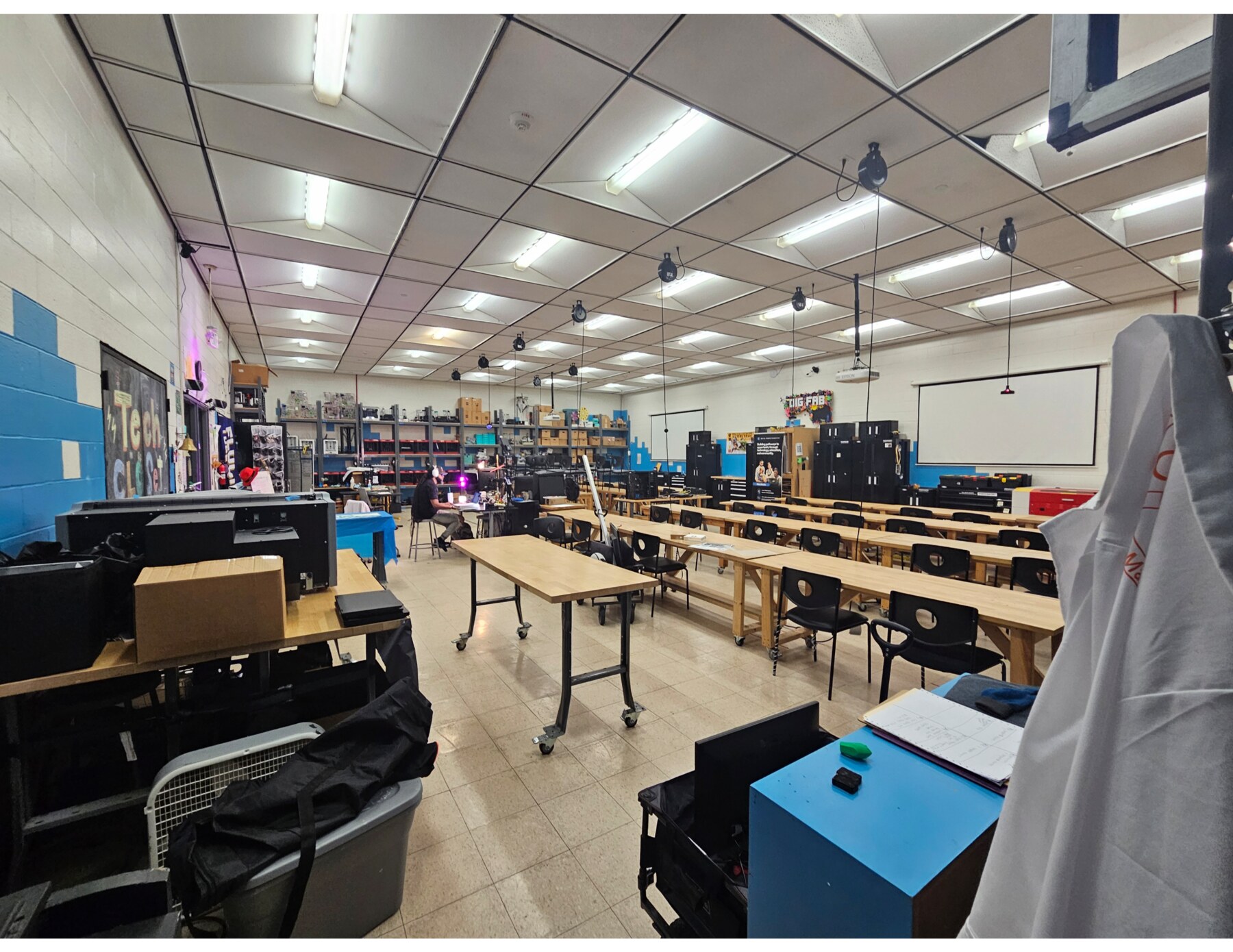 Existing school makerspace with worktables, equipment, and wide circulation