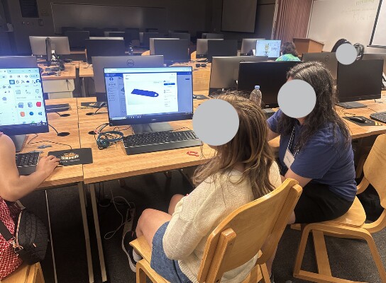 Students working with mentors on computer-based 3D modeling