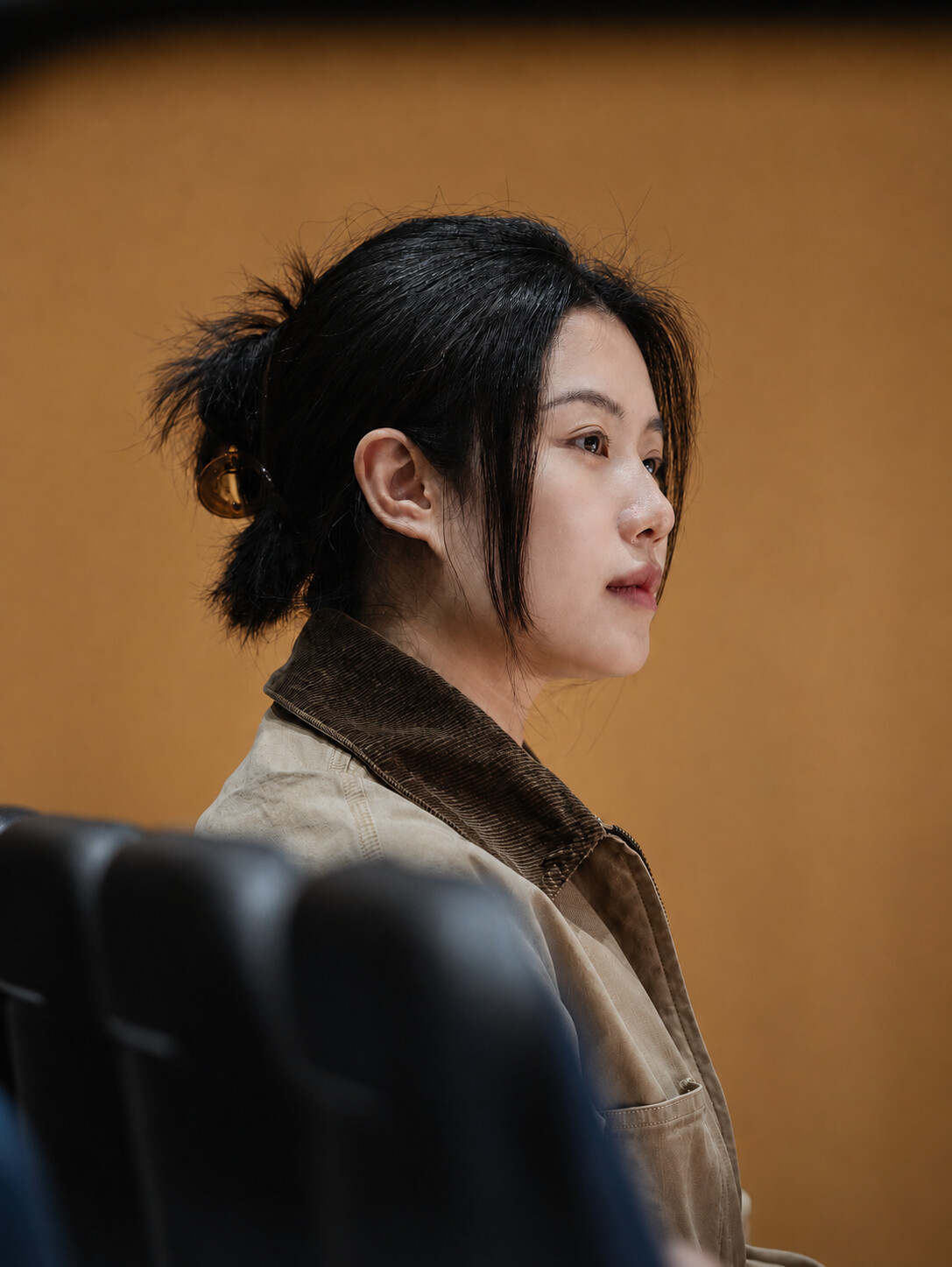 Portrait of Krystal Zhang against a warm brown wall
